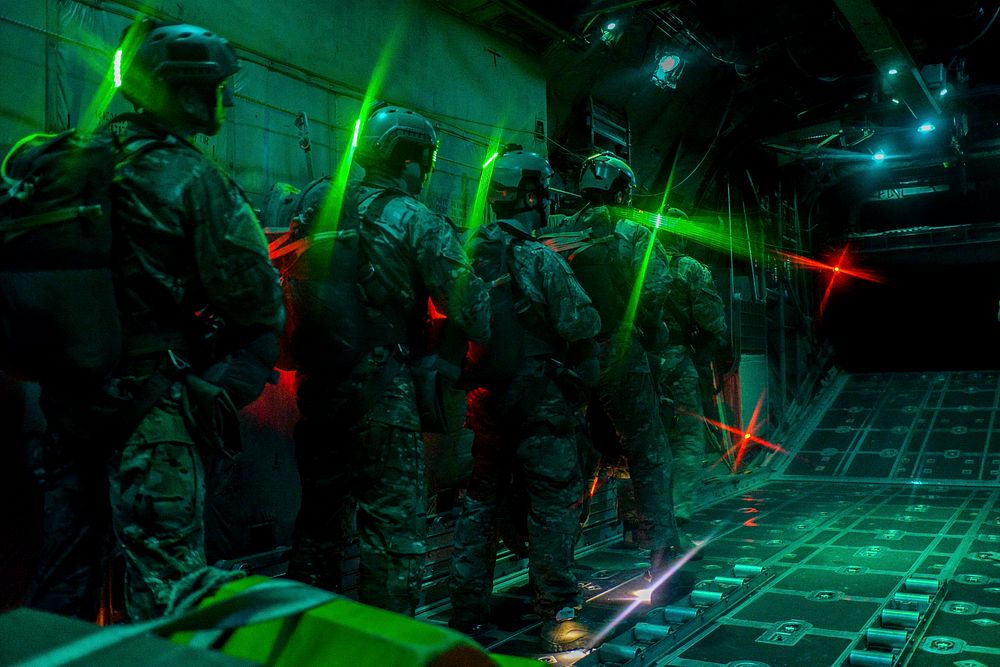 U.S. Air Force (AF) Survival Evasion Resistance Escape (SERE) specialists wait before preforming static line jumps as the…