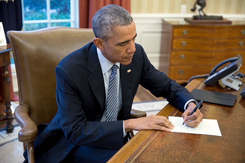 President Barack Obama signs a letter to Ileana Yarza, a 76-year-old letter writer in Cuba, in the Oval Office, March 14…