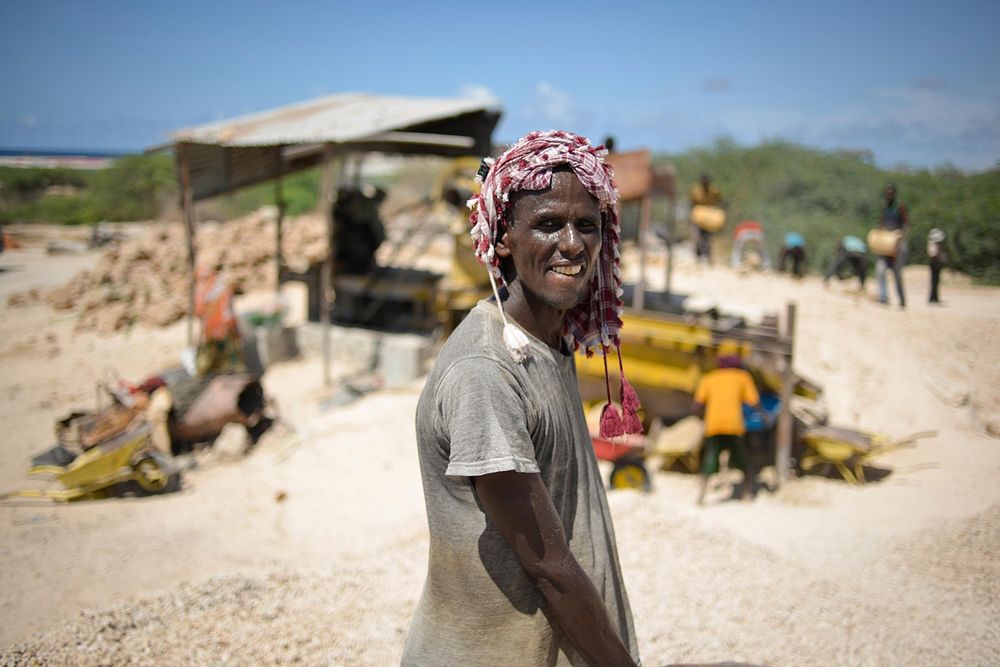 A worker poses next to a rock grinder at a small quarry near Mogadishu, Somalia, on April 10. AMISOM Photo / Tobin Jones.…