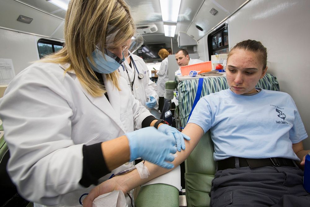 Phlebotomist Sandra Rodriguez, left, Miller Keystone Blood Center, Ewing, N.J., prepares to remove a blood donation needle…