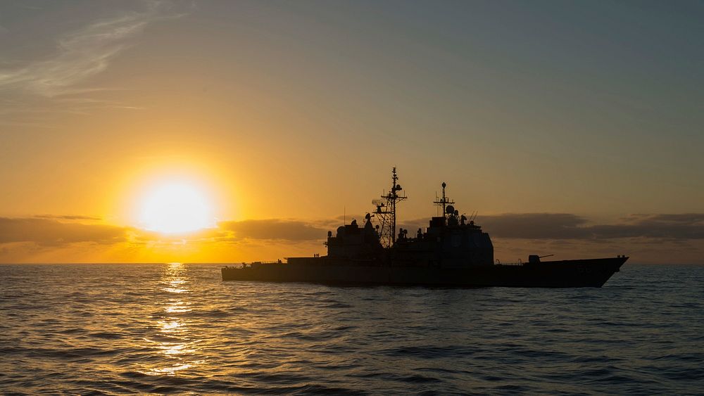 The sun rises over the Ticonderoga-class guided-missile cruiser USS Hue City (CG 66) in the Atlantic Ocean March 28, 2018.