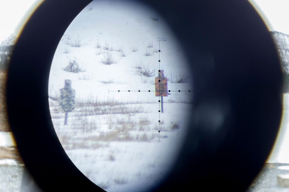 Long-distance targets are seen through a spotting scope as paratroopers assigned to the 1st Squadron, 40th Cavalry Regiment…