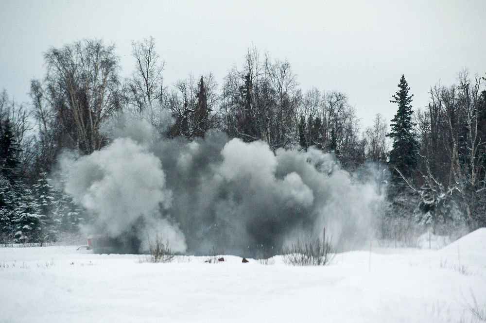 Explosive charges detonate throwing snow and debris into the air as Airmen assigned to the 673d Civil Engineer Squadron…