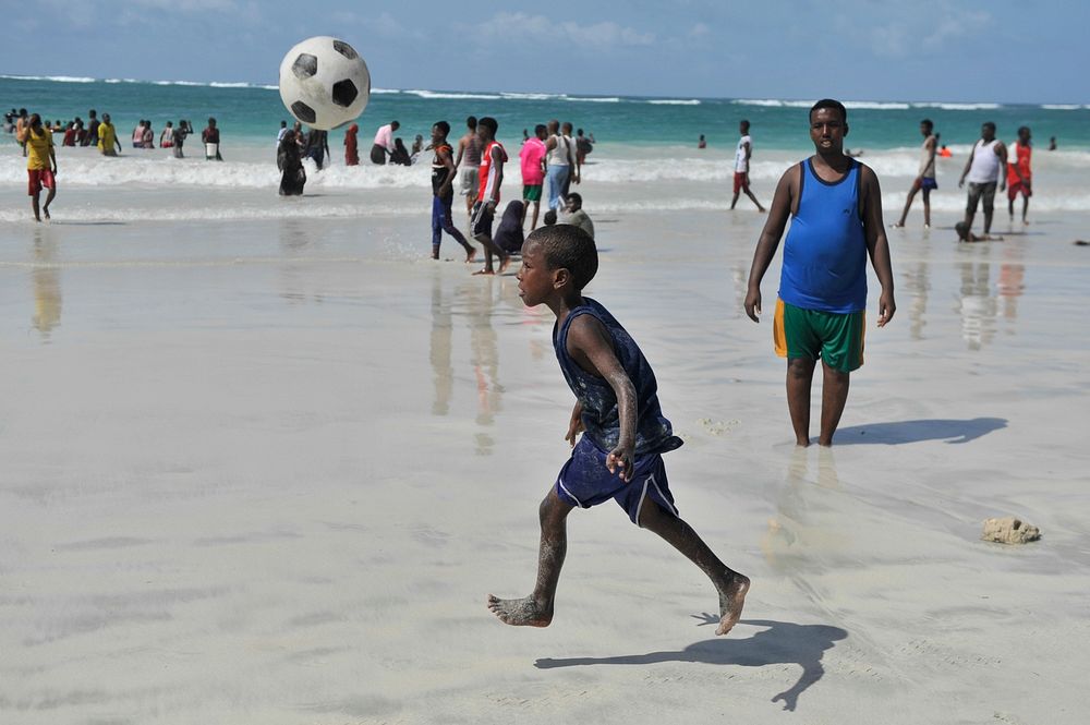 A young boy plays a ball at Lido beach during his holdiay in Mogadishu, Somalia on June 12, 2015. AMISOM Photo / Ilyas…