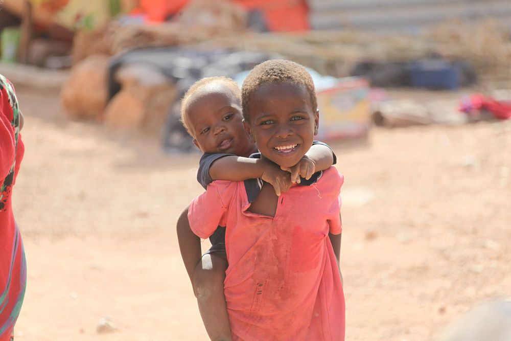 Two children affected by recent flooding in the Hiraan region of Somalia can be seen in a temporary camp set up near the…