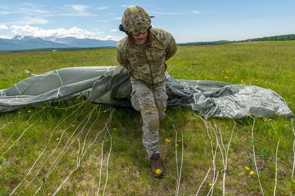 An Airman assigned to the 3rd Air Support Operations Squadron gathers up his parachute after conducting an airborne…