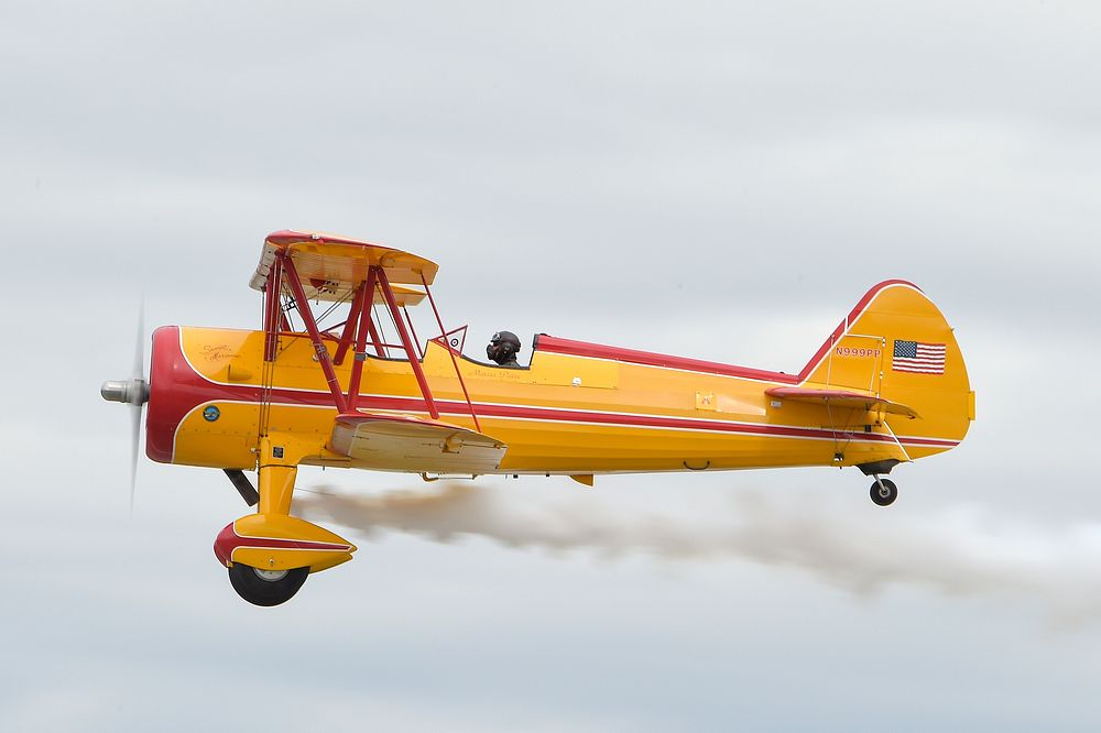 Marcus Paine pilots his 1941 Stearman airplane during the Arctic Thunder Special Needs and Family Day at Joint Base…