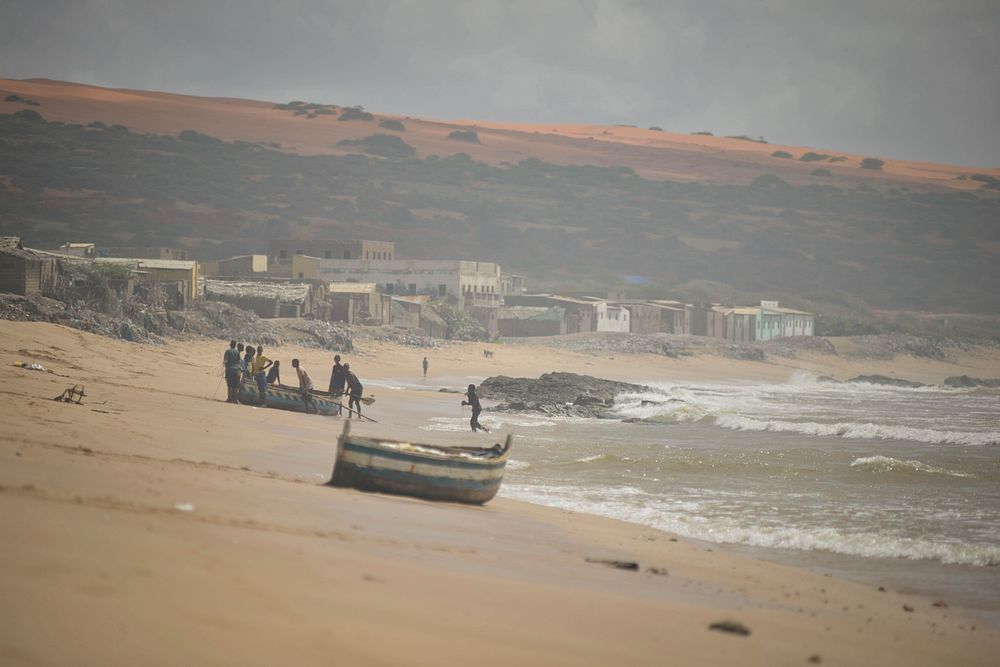 Men pull a fishing boat up onto Barawe's beach in Somalia on August 23, 2016.