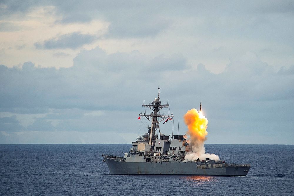 The Arleigh Burke-class guided-missile destroyer USS Benfold (DDG 65) fires a standard missile (SM 2) at a target drone as…