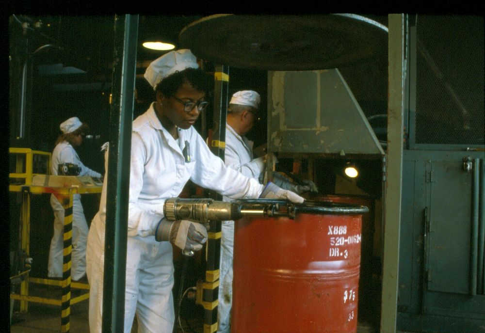 Chemical operator removes drum lid prior to sampling residues in plant 1, the sampling plant. Original public domain image…