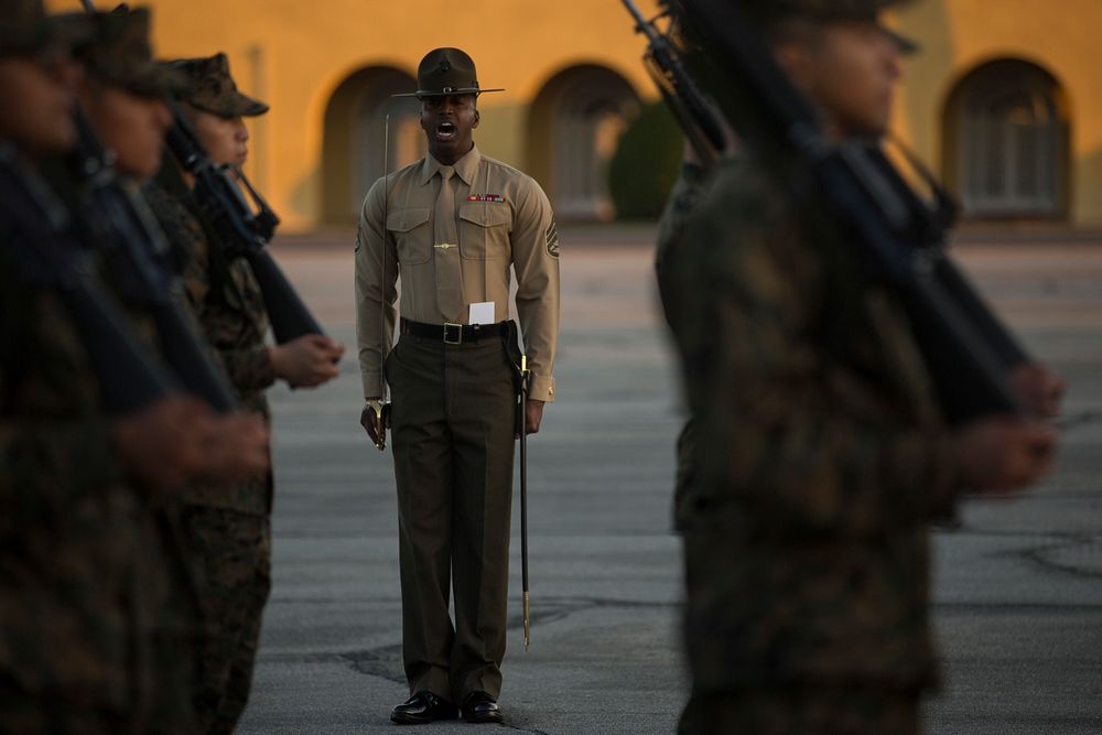 A U.S. Marine Corps drill instructor with Alpha Company, 1st Recruit Training Battalion, gives his platoon a command during…