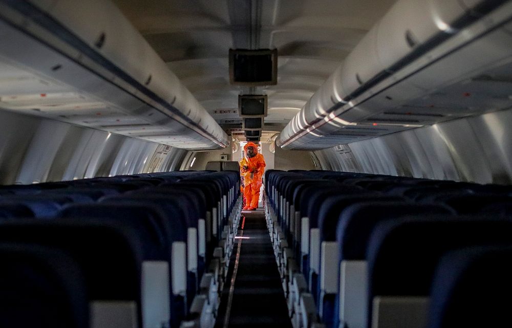 Man in orange hazard suit on plane. Original public domain image from Flickr