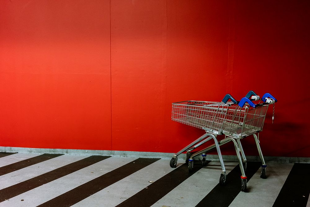 Shopping trolleys by red wall. Original public domain image from Flickr