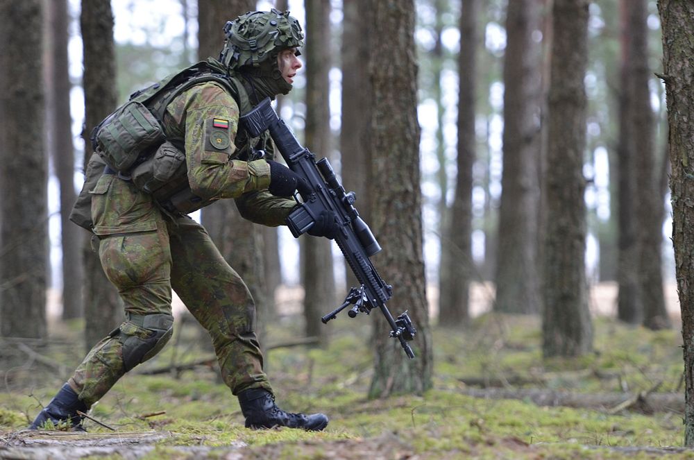 A Lithuanian soldier assigned to the Grand Duke Algirdas Mechanized Infantry Battalion steps cautiously through the forest…