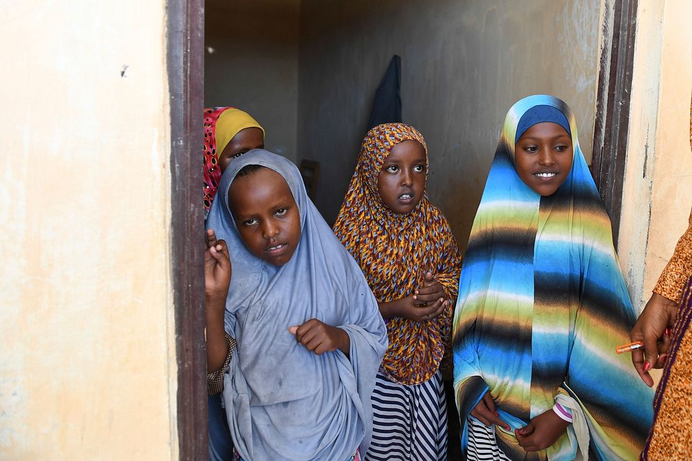 Young girls stand infront of their class during the AU Peace and Security Council delegation's visit to their school built…