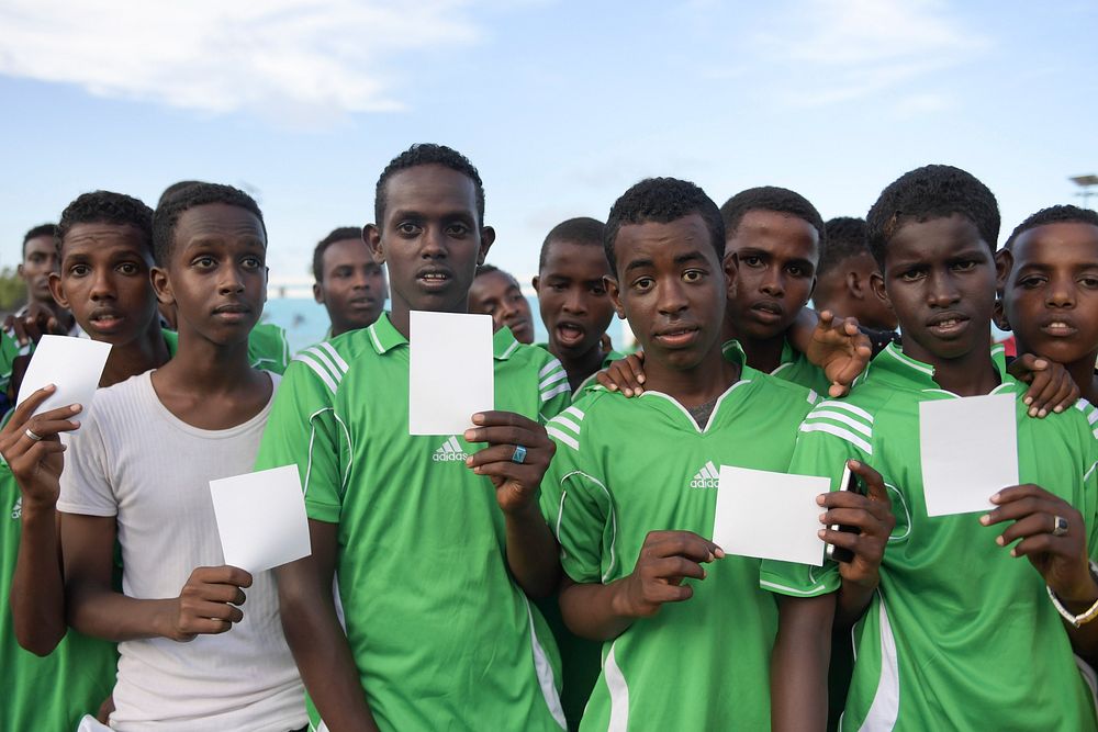 Somalia youth hold white cards as symbols of peace, at a ceremony to mark International Sports Day for development and peace…