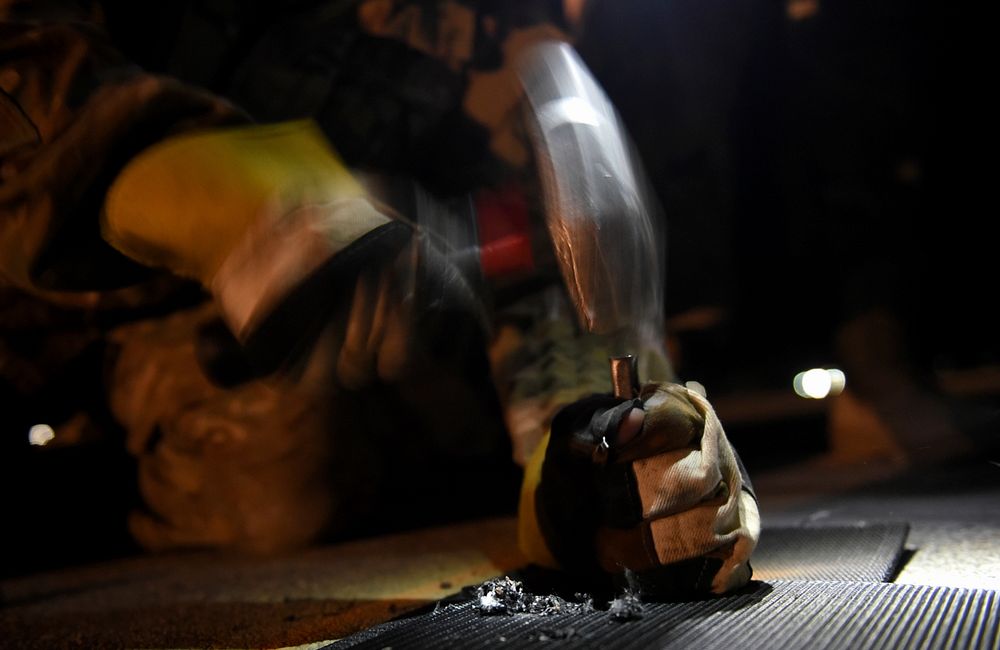 U.S. Air Force Airman 1st Class Brandon Ramirez of the 455th Expeditionary Civil Engineer Squadron punches a hole into a…