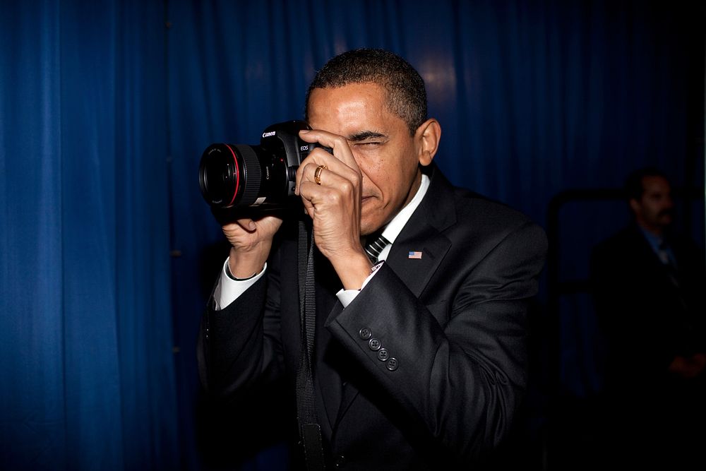 President Barack Obama takes aim with a photographer's camera backstage prior to remarks about providing mortgage payment…