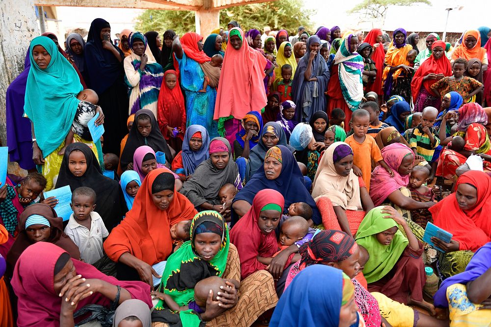 Women and children wait to receive food at an Internally Displaced Persons camp in Doolow, Gedo region, Somalia on June 12…