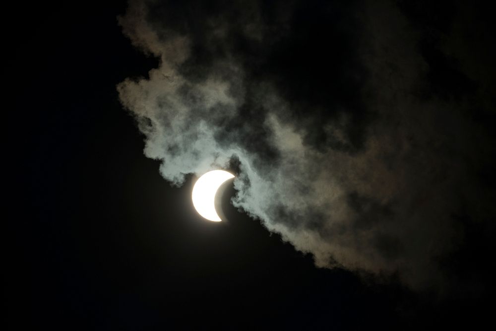 A cloud engulfs the Solar eclipse seen from the U.S. Department of Agriculture (USDA) headquarters' Peoples Garden, in…