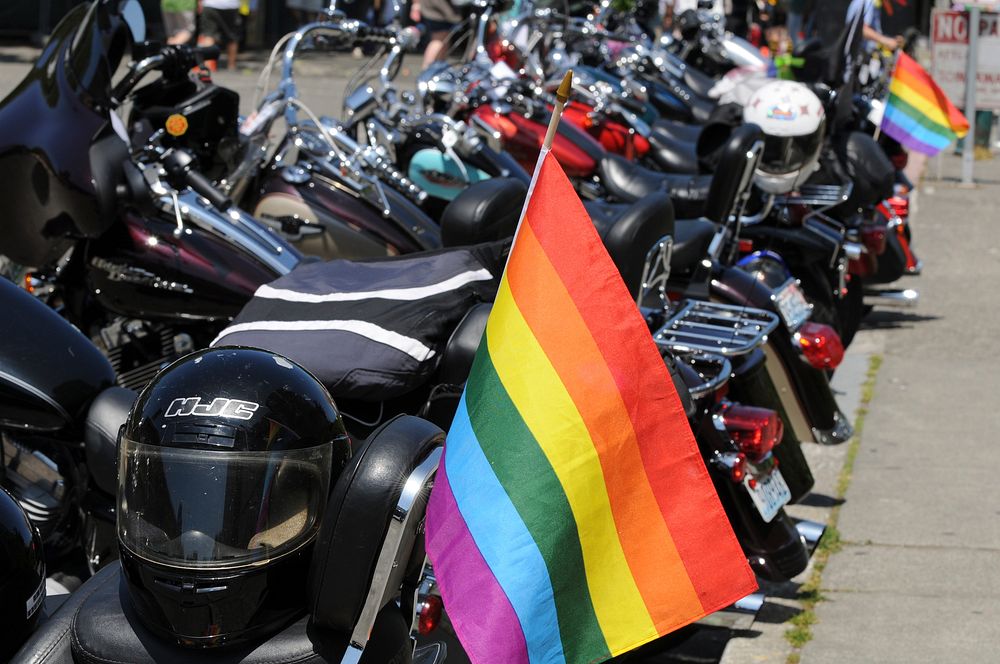 Parked motorcycles with lgbtq flag. Free public domain CC0 photo.