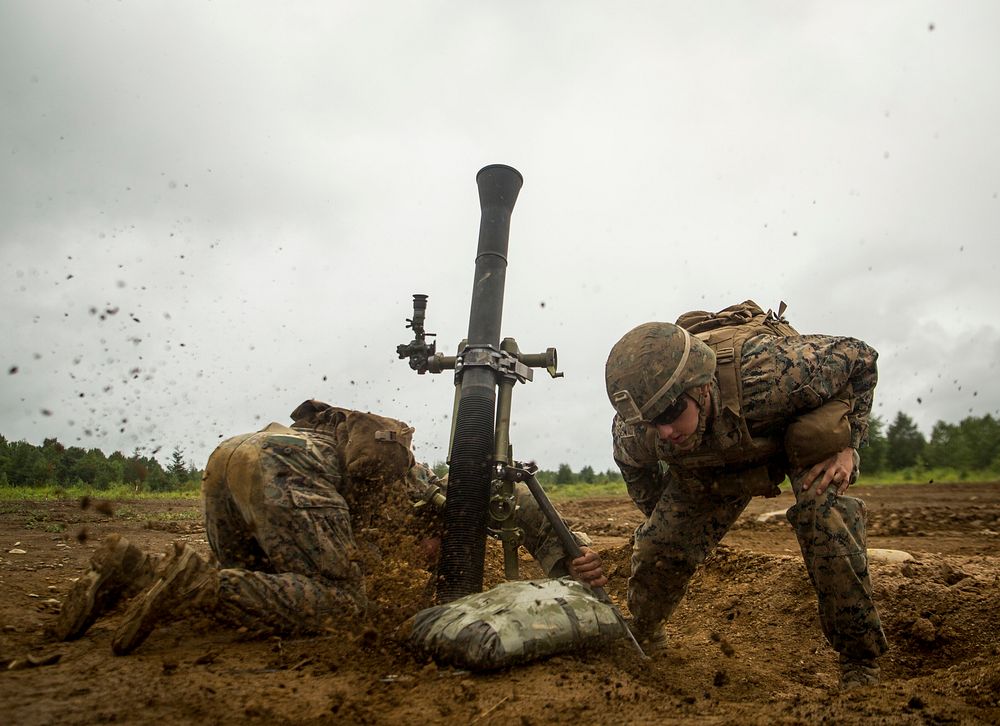 Lance Cpl. John Cavender (left) and Lance Cpl. Matthew Daily (right) shoot an M252 81mm medium weight mortar system Aug. 13…