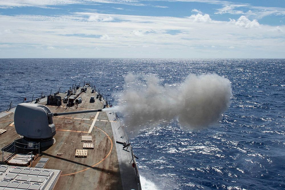 The forward-deployed Arleigh Burke-class guided-missile destroyer USS Stethem (DDG 63) fires its 5-inch gun during a live…