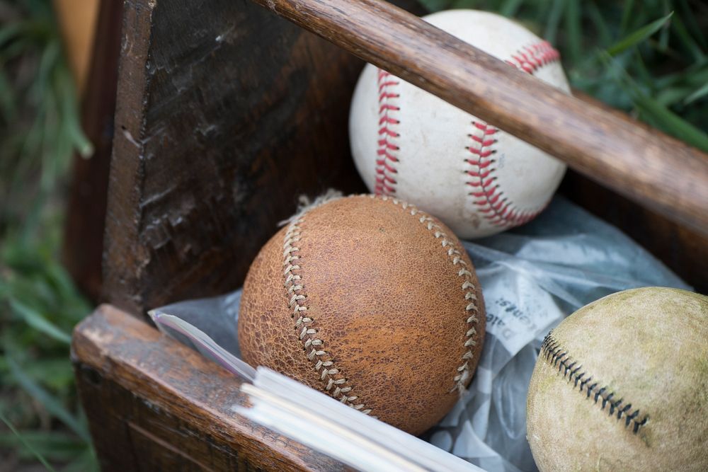 Baseballs used during a historic baseball game being played where uniforms of the period are worn and they follow the…
