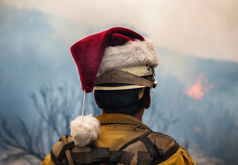 A fire fighter looks over the horizon while wearing a Santa hat at the Thomas fire, Los Padres National Forest, CA. Original…
