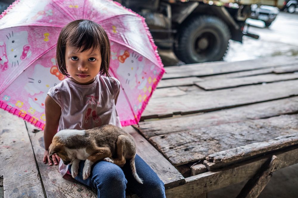 Little girl holding puppy, Nueva Vizcaya, Philippines, July 2017.