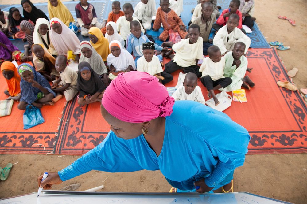 Learning to read and write, Nigeria. Damisa Rahila, a volunteer of the USAID funded SMILE activity teaches children In…