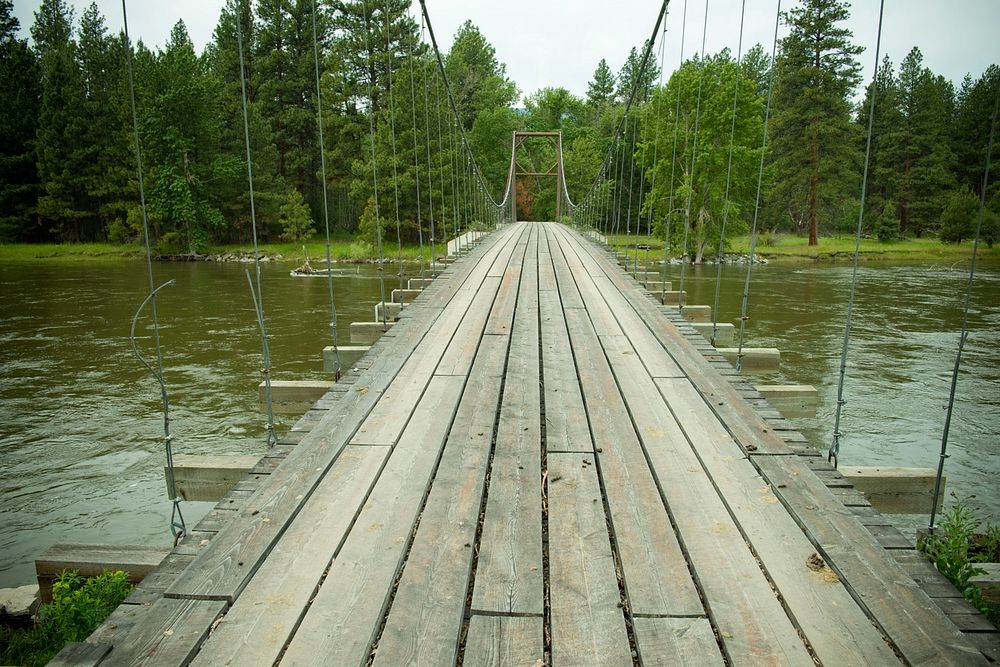 The Bitterroot River runs adjacent to Bart Morris' property near Lolo, Mont. A suspension bridge crosses the river leading…