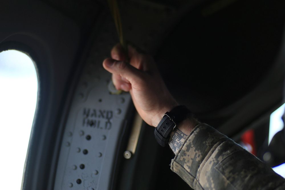 Cpl. Rory Hamill, a combat-wounded Marine, holds onto an overhead strap as the UH-60L Black Hawk he's flying in lifts off…