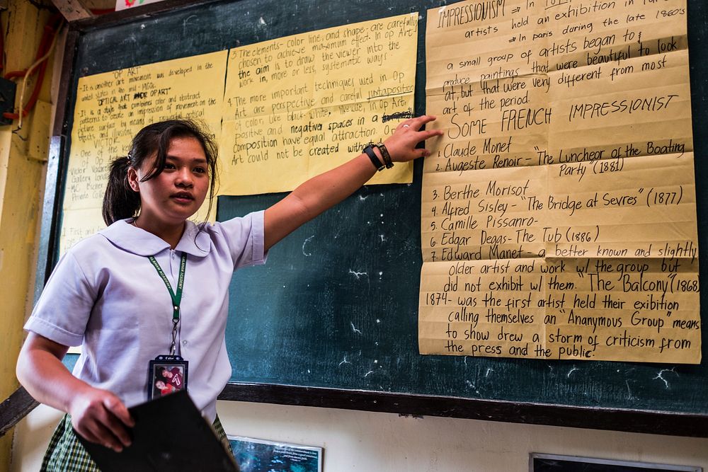 Student presenting homework on blackboard, Imugan, Nueva Vizcaya, Philippines, July 2017.