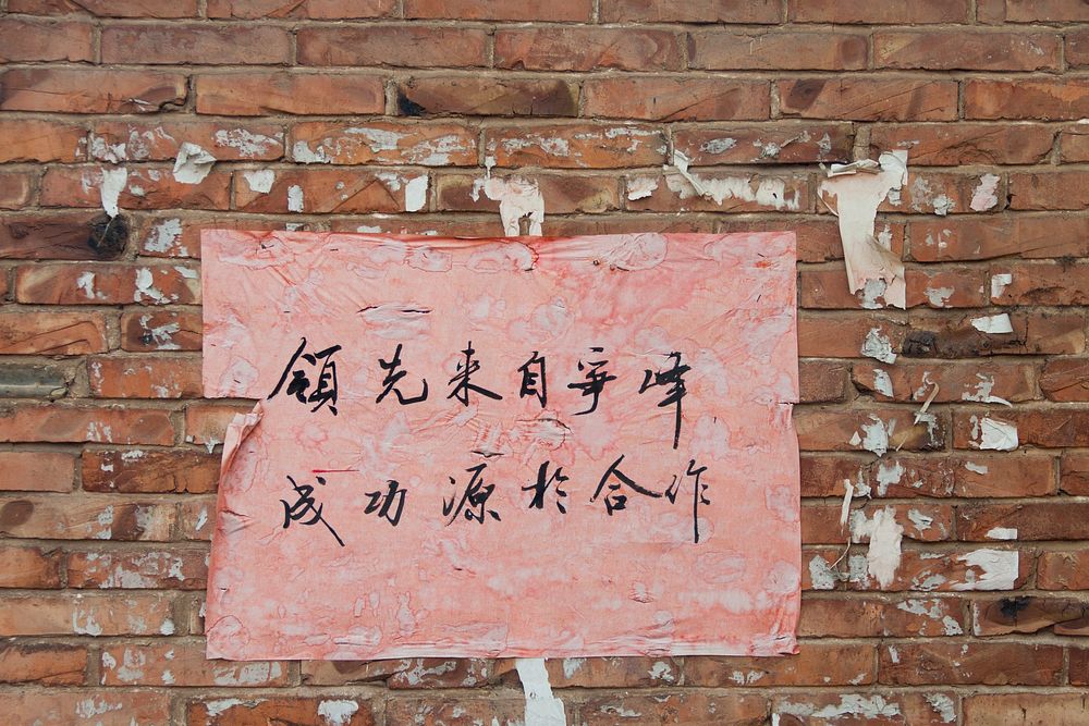 Chinese language sign on brick wall texture. Free public domain CC0 photo.