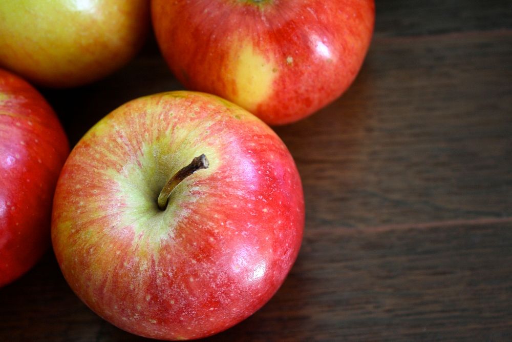 Closeup on red apples on wooden table. Free public domain CC0 photo.