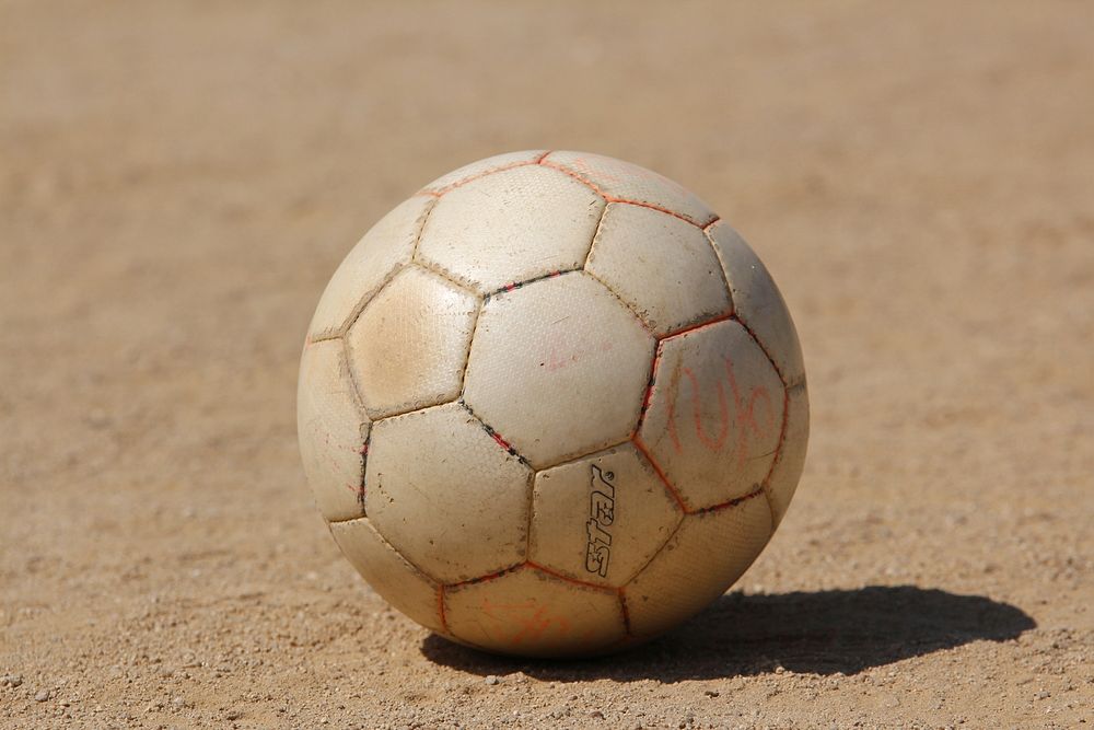 Closeup on football in soil. Free public domain CC0 photo.