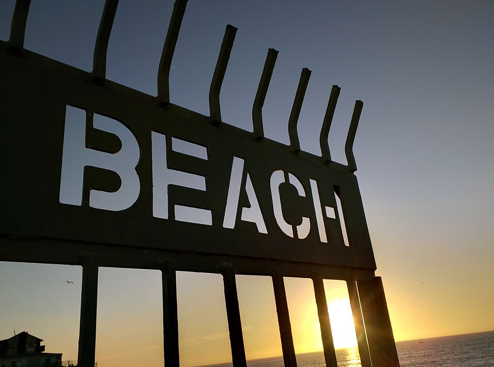 Beach sign silhouette during sunset. Free public domain CC0 photo.