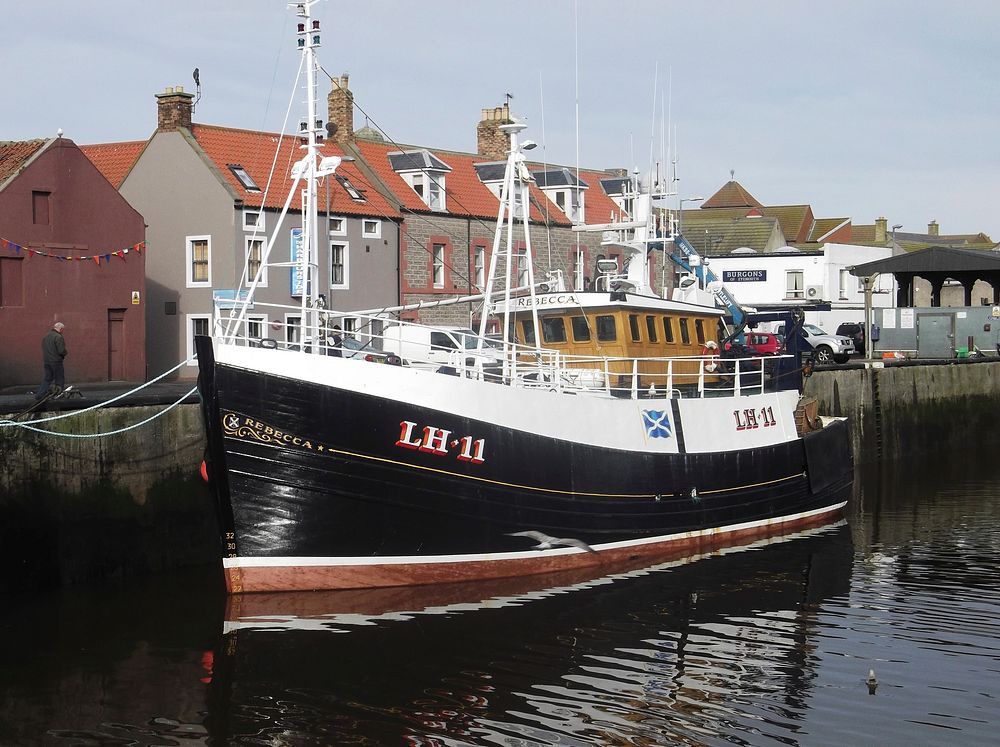 Black fishing boat at dock. Free public domain CC0 photo.