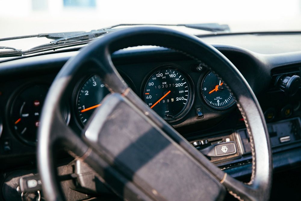 Side view of interior of a car with speedometer, dashborad and windshield in the background