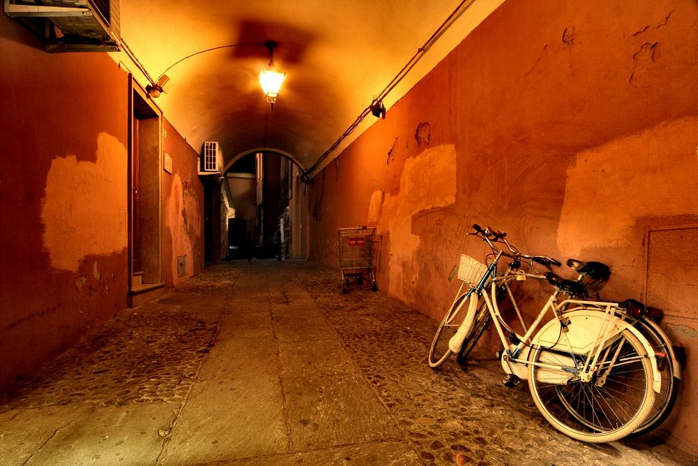 Two bicycles parked against the wall during night time