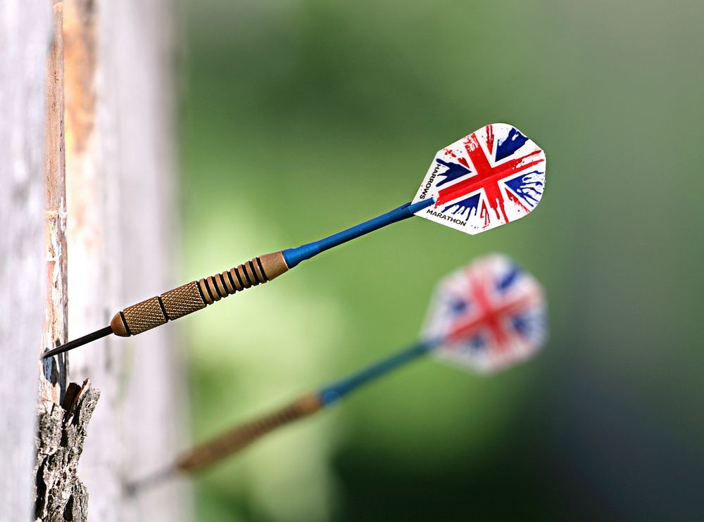 Closeup of darts on wall outdoors. Free public domain CC0 photo.