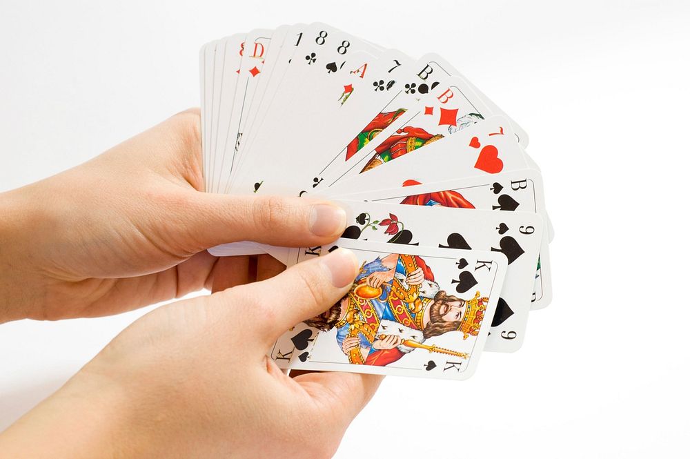 Free hands holding playing cards public domain CC0 photo.