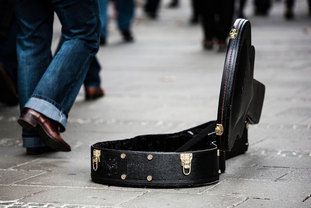 Street performance with guitar case on the pavement. Free public domain CC0 photo.