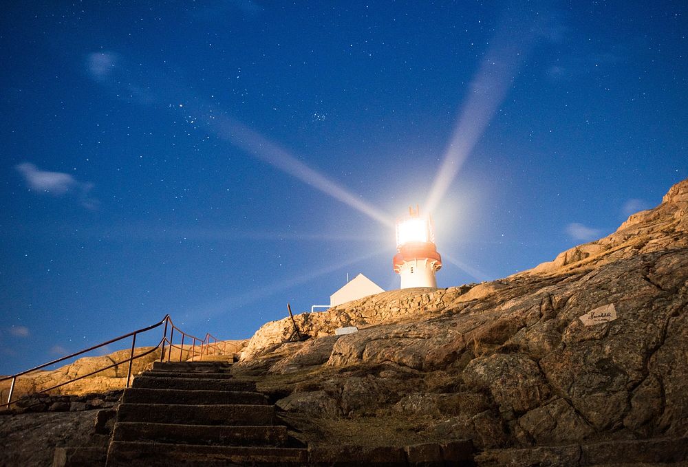 Lighthouse on a cliff near seashore. Free public domain CC0 photo.