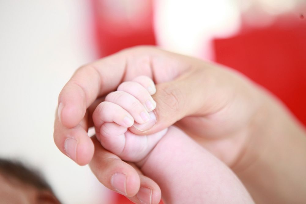 Father holding baby hand. Free public domain CC0 photo.