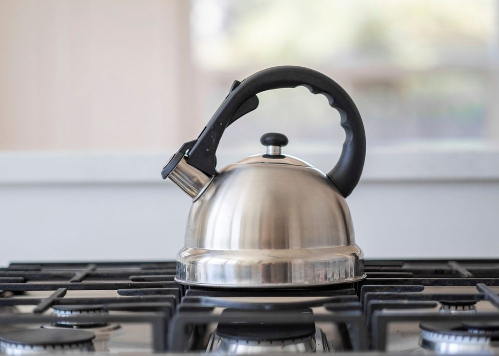 Free steel tea kettle with boiling water on gas stove in the kitchen image, public domain CC0 photo.