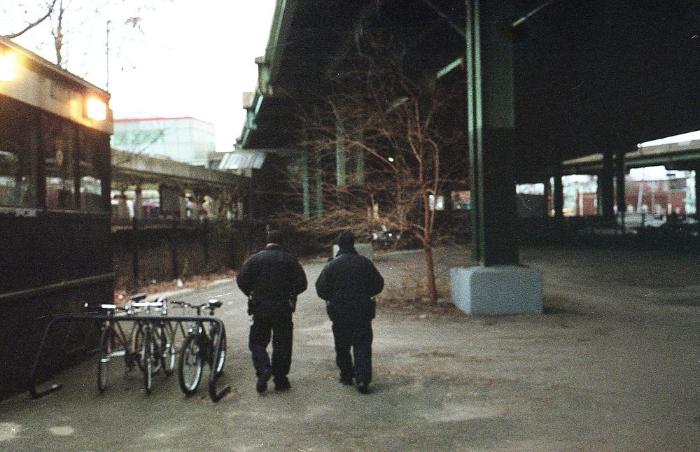Rear view of two men walking beneath the bridge with parked bicycles on the street