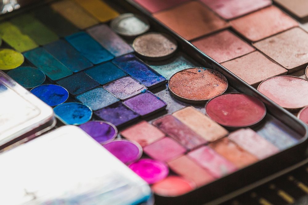 Close up of colorful eye eyeshadow and blush palette with circular and square containers, free public domain CC0 image.