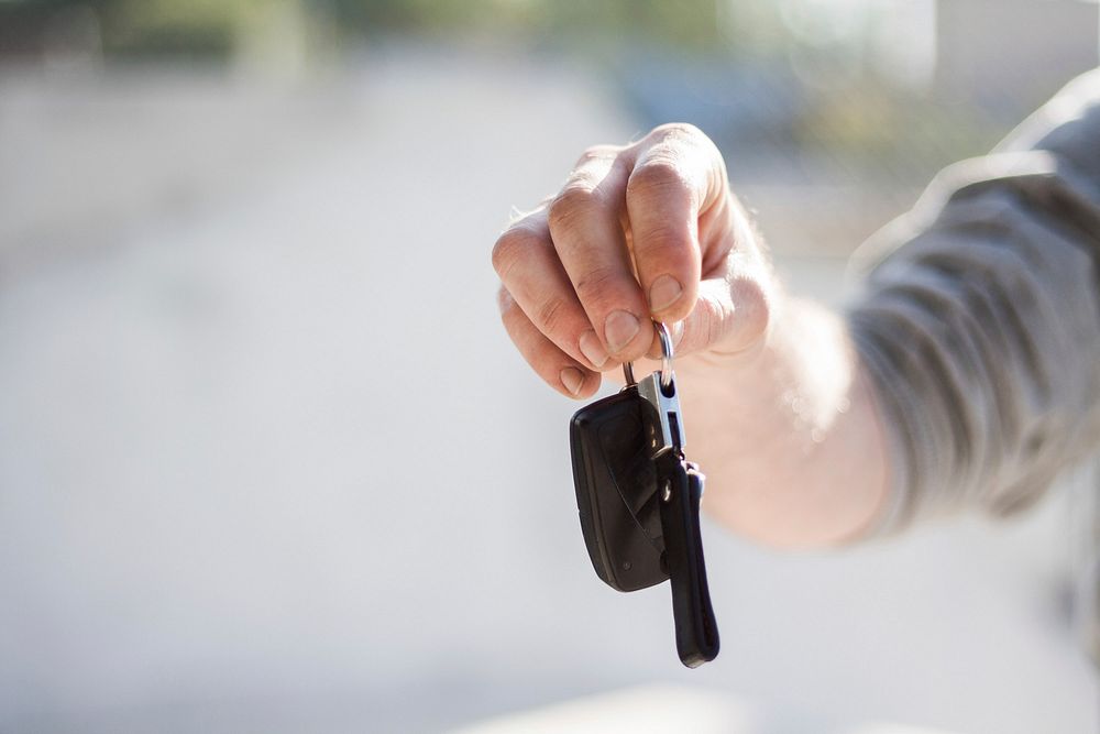 Free man holding car key image, public domain people CC0 photo.